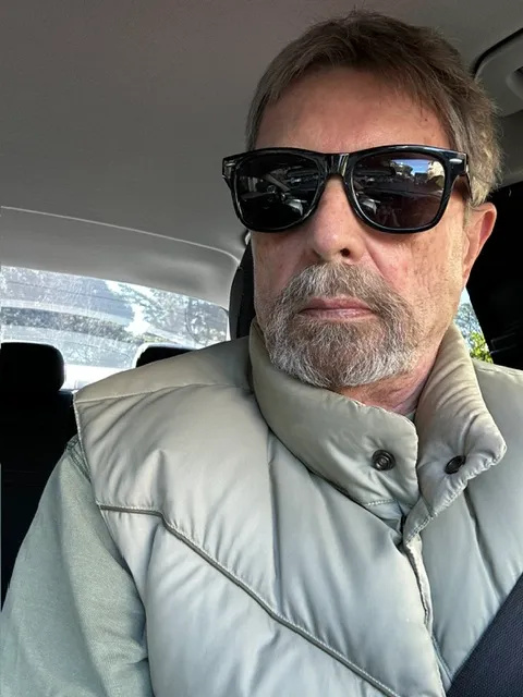 Vernon Pipkin in his car, in sunglasses and a sage vest