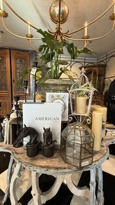 Home decor vignette with candles, lantern, and antique table